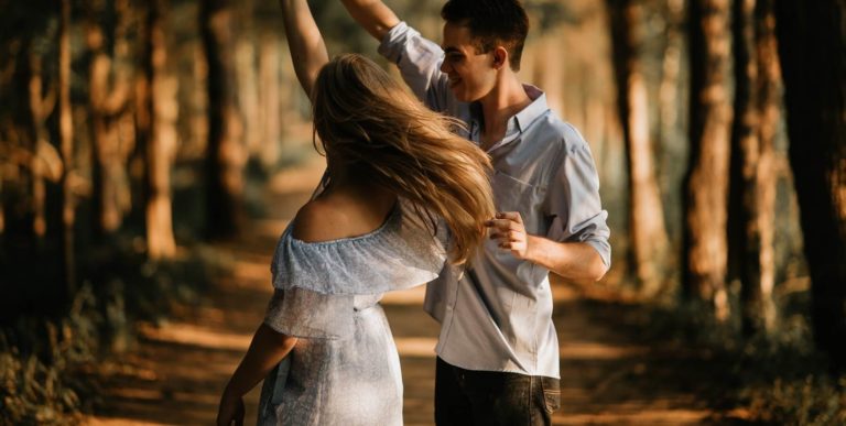 happy couple dancing in the forest