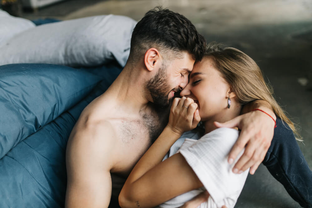 Topless man with his beautiful transgender girlfriend cuddling in bed