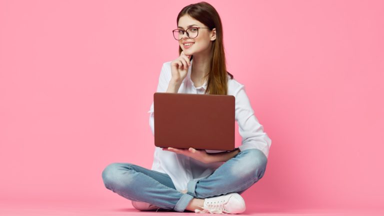 girl with glasses on her laptop contemplates whether paid dating sites are better