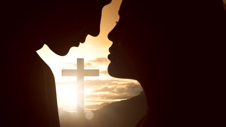 christian couple almost kisses, cross in background