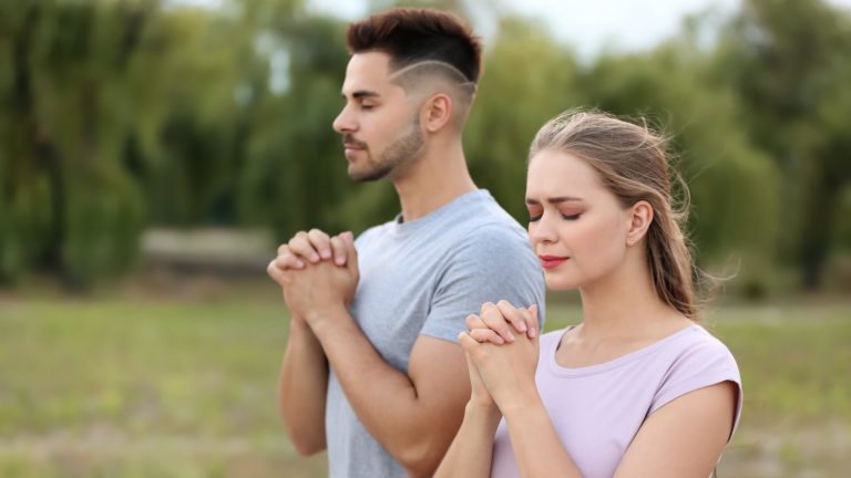 Christian man and woman praying in the park