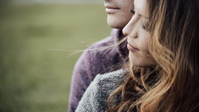 couple in a serious relationship hugging in the wind