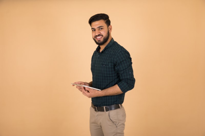 single muslim man holds his tablet