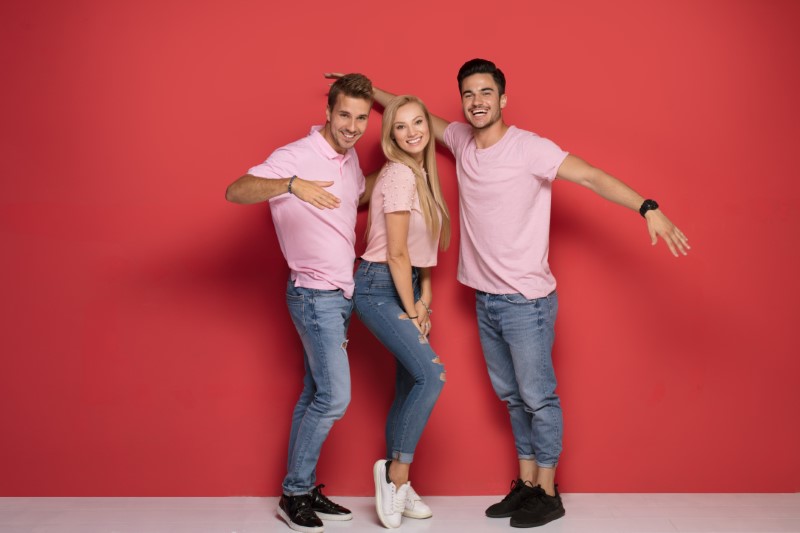 one female and two male bisexual singles in matching shirts posing