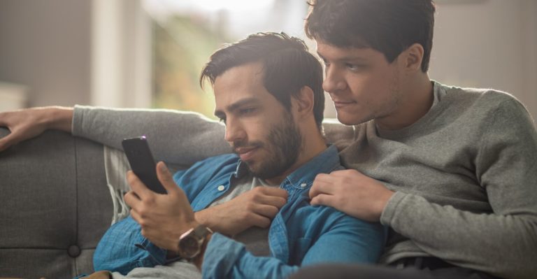 gay couple looks at smartphone
