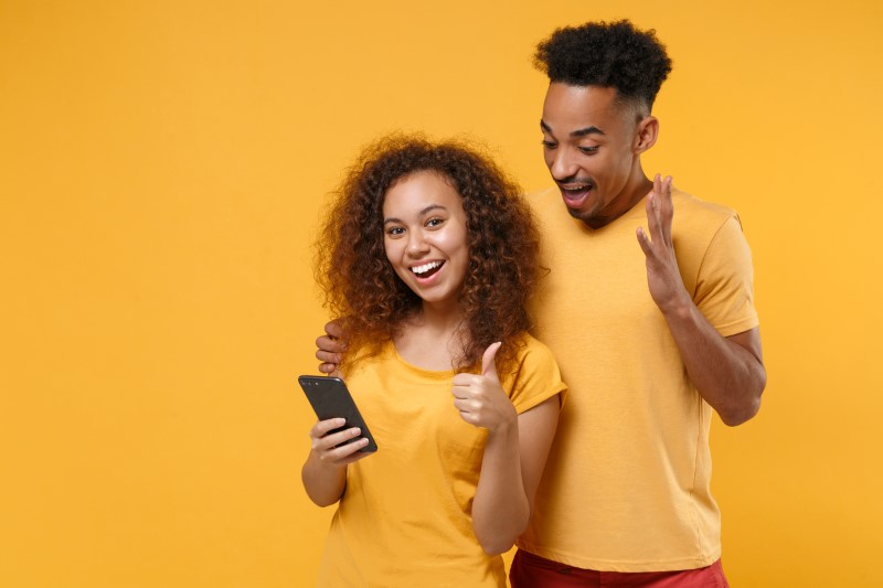 man and woman happy because of dating app on their phone