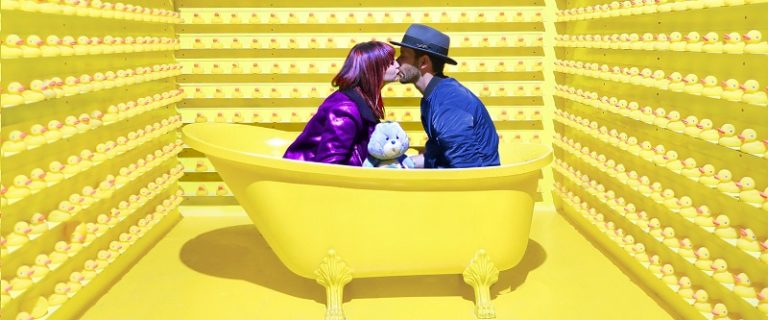 weird dating couple in yellow bathtub surrounded by rubber duckies