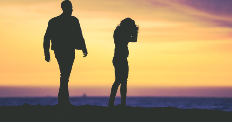 how to handle arguments in a relationship: man walks towards his girlfriend in the sunset to repair after an argument