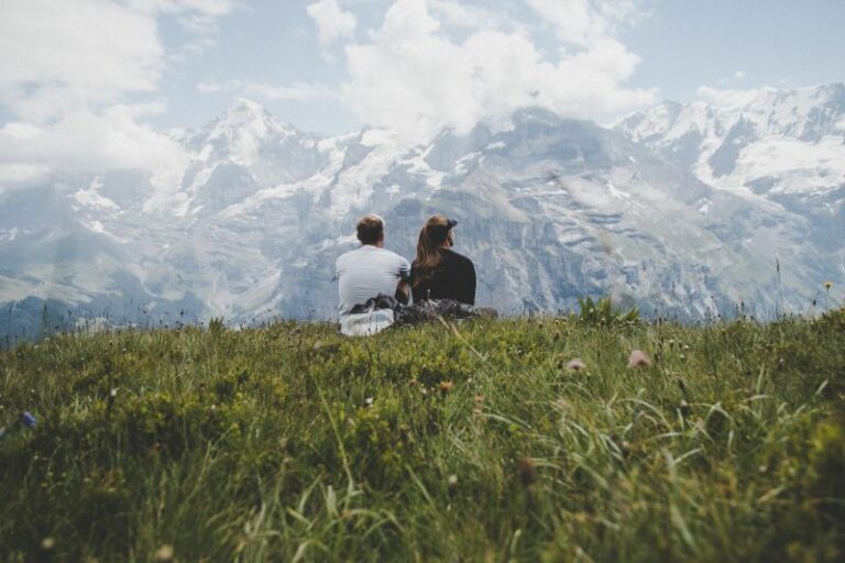 two people sitting closely together on the grass