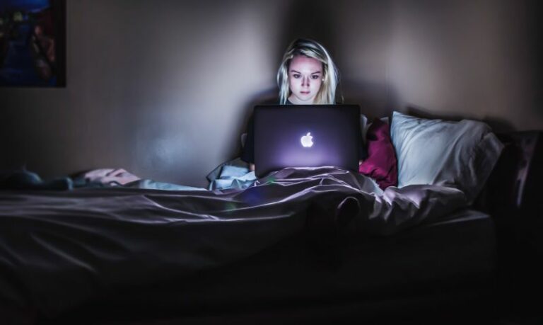 woman sitting in the dark with her laptop