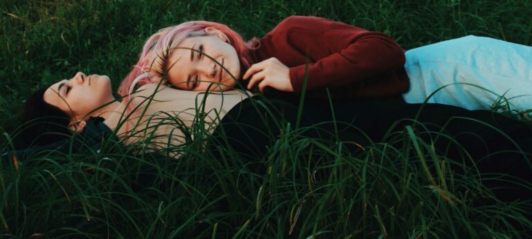 girlfriends lying on the grass cuddling