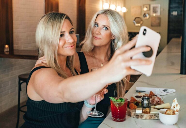 two women review passionmature profiles on phone