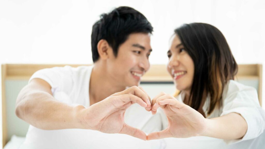 korean dating couple making heart shape with hands